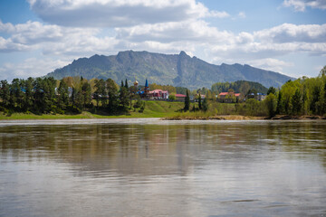 Obraz premium View from the Love Stone over the Biya River with the town of Turochak on the opposite bank. Concept of serenity, connection, and sacred places in wild Russian nature
