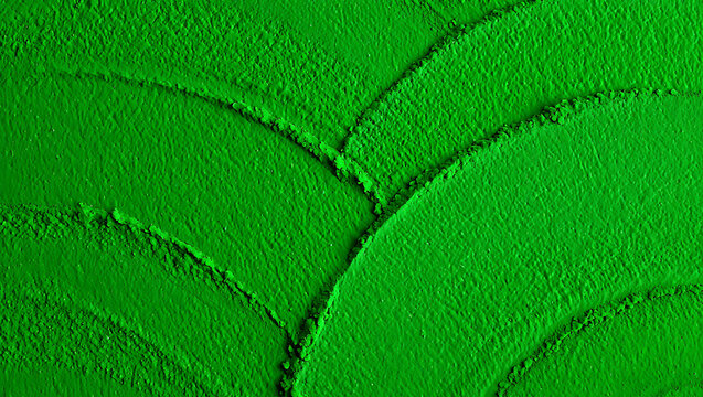Aerial view of a vibrant green field with curved patterns and textured surface