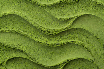 Closeup of green matcha powder texture with wavy patterns on a surface isolated on white background
