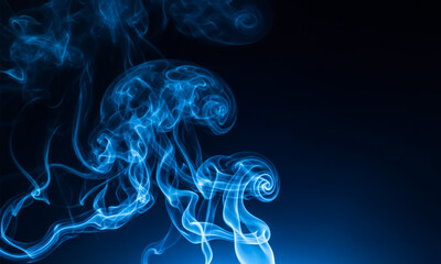 Fototapeta premium Abstract blue smoke swirls and curves against a dark solid background
