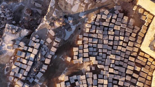 Aerial view of the marble quarry where stacked stone blocks are located at sunset. 