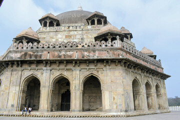 Fototapeta premium low angle view of arched sandstone arcade and massive dome of sher shah suri tomb with chhatri pavilions and decorative parapet in sasaram bihar india historic