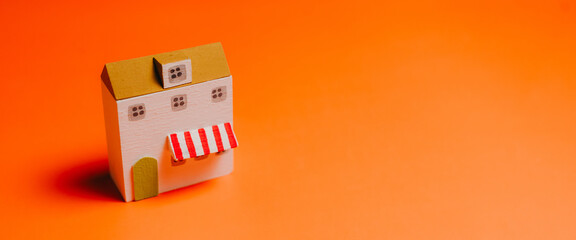 Franchise business. Miniature house orange background small model wooden house toy building home concept real estate property investment architecture decoration