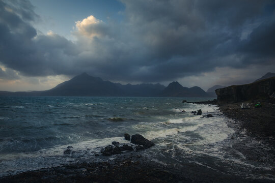 Moody landscape of Elgol beach during a storm. Dark rain clouds hanging over the Cuillin mountains and rough sea on the Isle of Skye, Scottish Highlands