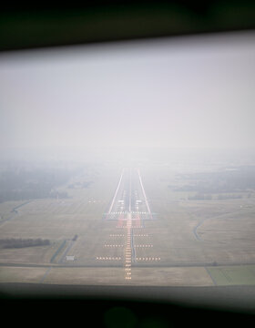 Airplane approaching zuerich airport runway in foggy weather