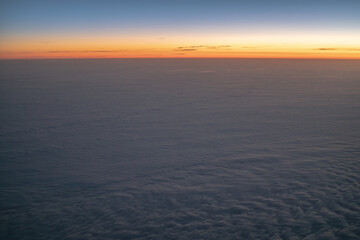 Fototapeta premium Horizon over clouds during sunrise from airplane