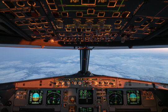 Airplane cockpit flying over norwegian winter landscape at sunrise