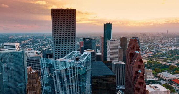 Tops of skyscrapers against pink cloudy sky. Downtown Huston, Texas, USA at sunset time.