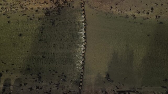 Drone rising above stepping stones crossing the River Lerryn in Cornwall, England, with clear water flowing through a peaceful woodland landscape.