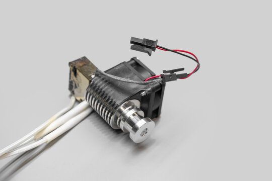 3d printer hotend assembly cooling fan component and heat sink on grey background.