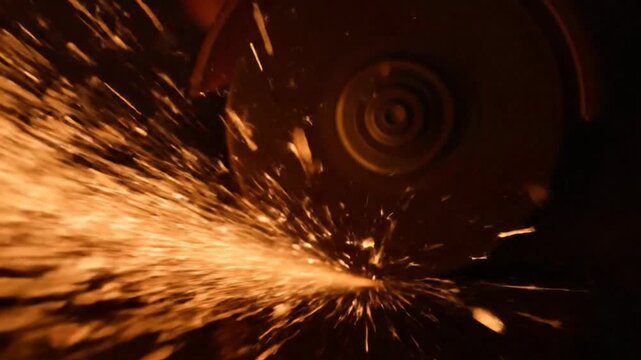 Close-up of sparks flying from grinding metal in a workshop.