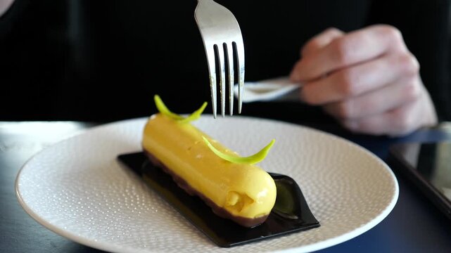 Elegant yellow yuzu lemon petit gateau dessert on white plate, eaten with a fork at a
restaurant. This description is formulated as someone would search for it online