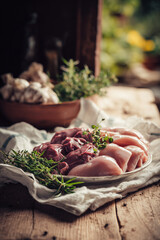 Fresh raw meat with herbs on rustic wooden table. Natural protein food concept, farm to table, cooking ingredients, and healthy nutrition background.