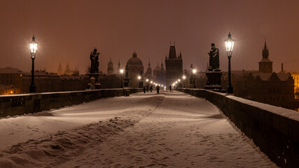 Obraz premium Winter morning with lit gas lamps on the snowy Charles Bridge