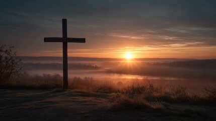 Serene sunrise over misty landscape with prominent wooden cross.