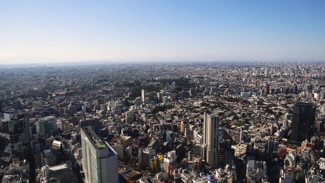 Tokyo, Japan, beautiful super wide aerial view of rooftops and skyscrapers, with skyline and city wards scenery, from the observation deck in a sunny day with a blue sky, Tokyo Metropolitan urban area