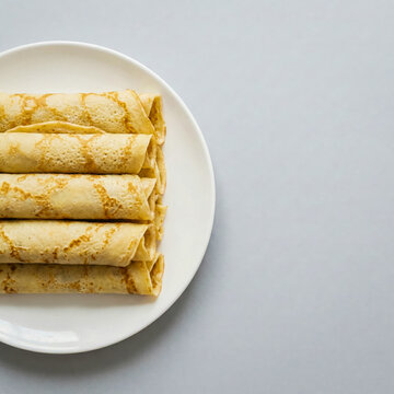 Stack of traditional Asturian Frisuelos crepes on white plate