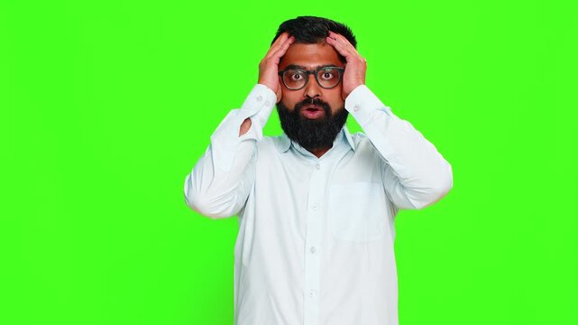 Indian man covers face with hands in tense motion expressing panic, emotional shock or mental stress reaction. Arabian guy isolated on chroma key background showing fear overload and nervous breakdown