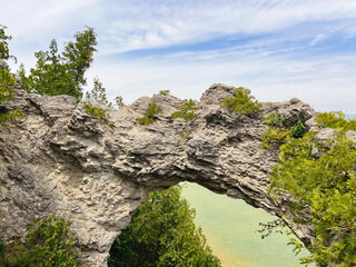Majestic Arch Rock Natural Limestone Formation on Mackinac Island, Michigan, USA. Looking through the geological formation to the turquoise waters of Lake Huron below.
