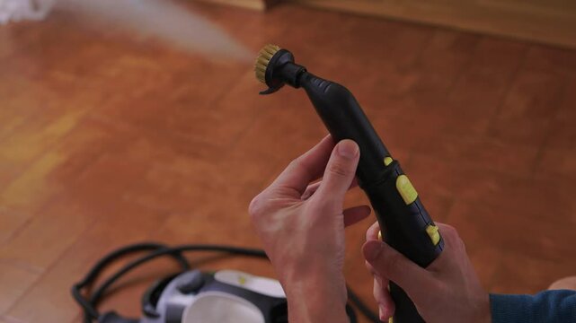 Household brushes examined closely, Two brushes analyzed in indoor setting, Person holding two black brushes inspecting bristle arrangement for household cleaning purposes