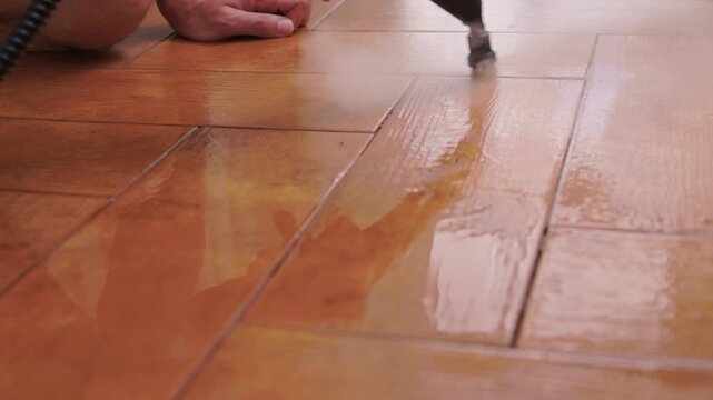Vapor spray on tile grout. Closeup of steam removing stubborn grime from ceramics. Satisfying vapor cleaning technique revealing pristine and spotless ceramic grout lines