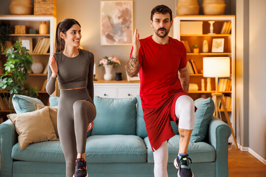 Couple doing high skips exercise while working out at home