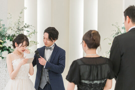 Bride reading a letter to her parents at her wedding (letter from parents, father, and bride, crying)