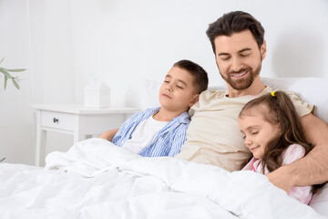 Obraz premium Happy father with his sleeping little children in bedroom