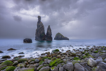 Dramatic volcanic sea stacks of Ilhéus da Ribeira da Janela rising from the Atlantic Ocean at a rocky pebble beach in Madeira, Portugal. © Miroslav Srb