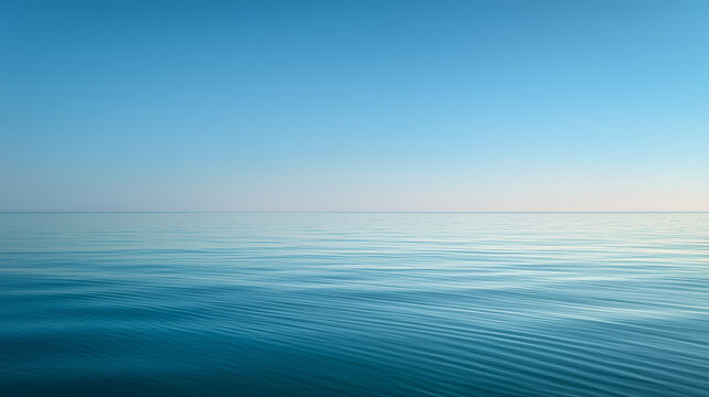 A serene wide-angle view of a calm turquoise ocean with a clear horizon line under a soft blue sky and gentle white clouds, creating a peaceful and minimalist landscape.