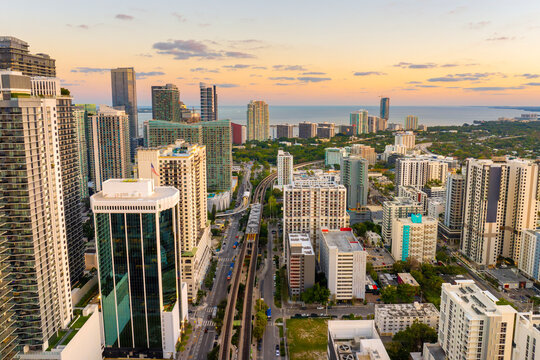Public train system in urban landscape of downtown Miami Brickell in Florida, USA. Tracks threading between skyscrapers at sunset