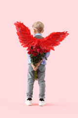 Obraz premium Cute little boy in cupid wings with bouquet of beautiful roses on pink background, back view. Valentine's Day celebration