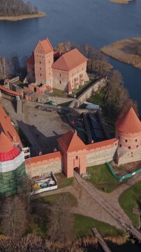 Vertical Screen Trakai Island Castle Traku Pilis In Lithuania Aerial View Trakai Island Castle Lithuania Showing Sweeping Drone Footage Over Medieval Brick Fortress On Island In Calm Lake,