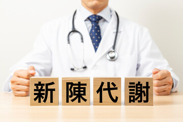 「新陳代謝」と書かれたブロックと医師