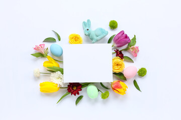 Obraz premium Blank card with toy bunny, Easter eggs and flowers on white background