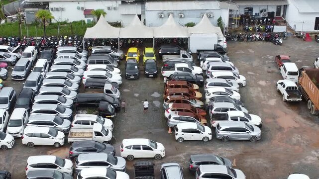 Aerial view of cars parked in a row for auction, there are various types of cars