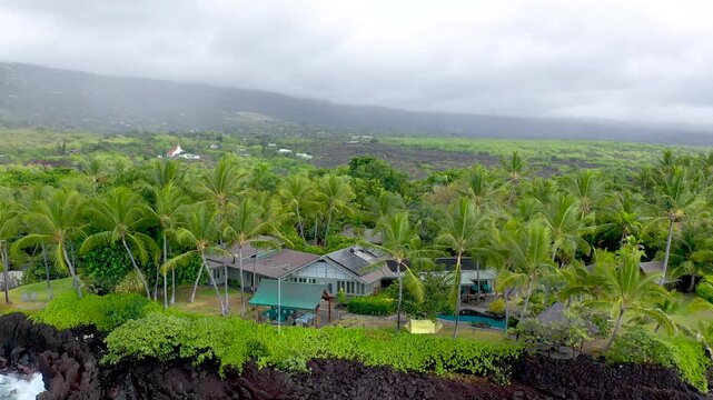 Aerial Orbit of Luxury Beachfront House on Volcanic Lava Rock Coast, Big Island Hawaii, 4K