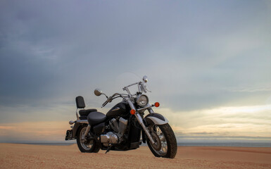 Naklejka premium A motorcycle rests beneath a vibrant sunset sky, evoking freedom, adventure, and independence, symbolizing open roads, personal journeys, and the endless desire to explore new horizons.