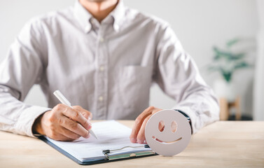 Fototapeta premium Survey form completion by man writing customer feedback for service satisfaction, happy face icon indicating excellent experience review ensures positive business quality check