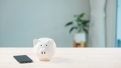 Digital savings mobile payment piggy bank phone online save smartphone devices rest on wooden desk,...