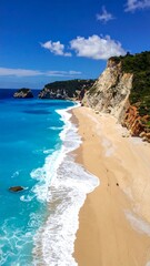 Turquoise water meets golden sand beneath a sunny sky, cliffs along the shore