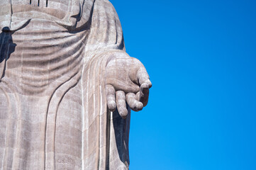 青空に差し出された仏像の手　慈悲と祈りを象徴するスピリチュアルイメージ