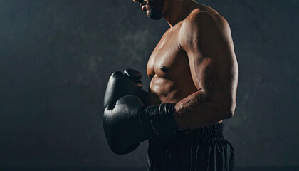 Half body shot of a boxer man standing sideways with gloves, background