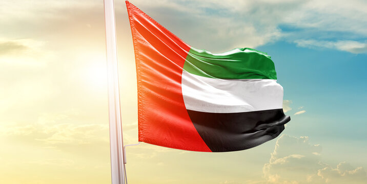 United Arab Emirates national flag waves on soft sky.