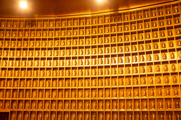 黄金の仏像が並ぶ壁面と反復する光の空間