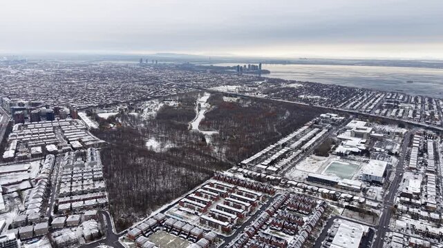 Aerial winter view of Montreal suburbs, snowy angrignon park and river near Lachine and Verdun under cloudy sky. g.