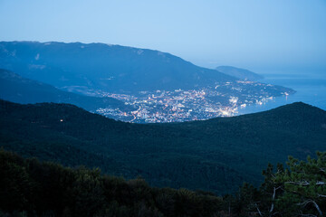 Evening seaside calmness, Serene coastal sunset landscape, Peaceful harbor illuminated at twilight amidst rolling green slopes