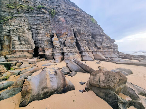 Eroded cliff face at Bar Beach Newcastle New South Wales Australia. Early morning with a grey cloudy sky.