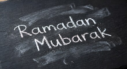 Fototapeta premium Ramadan mubarak message on chalkboard with white chalk writing dark background