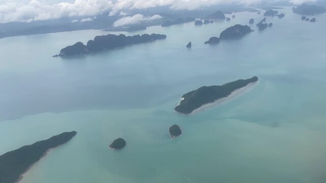 Aerial view of tropical islands surrounded by calm turquoise water and soft clouds. Remote island landscape with clear sea, coastal shapes, ideal for travel, tourism, nature getaway concepts